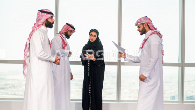 مجموعة من الرجال الاعمال السعوديين داخل مقر الشركة ، مناقشة جدول الاعمال و المهام ، سكرتيرة عربية سعودية خليجية تعمل على تنظيم المهام و الاعمال و تدوين الملاحظات  عبر جهاز تقني، الوحدة والعمل الجماعي