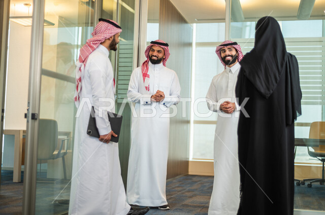 A Saudi Arabian Gulf working group discussing business issues, businessmen and businesswomen within a Saudi company, unity and teamwork, achieving the company’s goals, developing work
