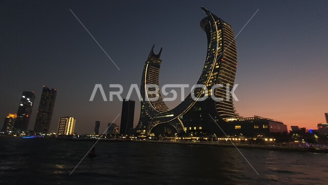 أماكن ومعالم مشهورة ومميزة، التطور والتقدم العمراني في قطر، برج كتارا التوأم في منطقة لوسيل الدوحة، الفن الهندسي المعماري للابراج وناطحات السحاب في وقت الغروب، مناطق سياحية لجذب السياح من شتى أنحاء العالم