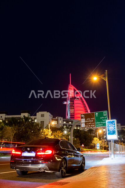 النمو والتطور العمراني للفنادق والمنتجعات في الإمارات العربية المتحدة، الفن الهندسي المعماري على الطراز الحديث للأبراج وناطحات السحاب، برج العرب المضاء ليلا في مدينة دبي، جذب واستقطاب السياح من انحاء العالم، حركة مرور السيارات في الشوارع العامة