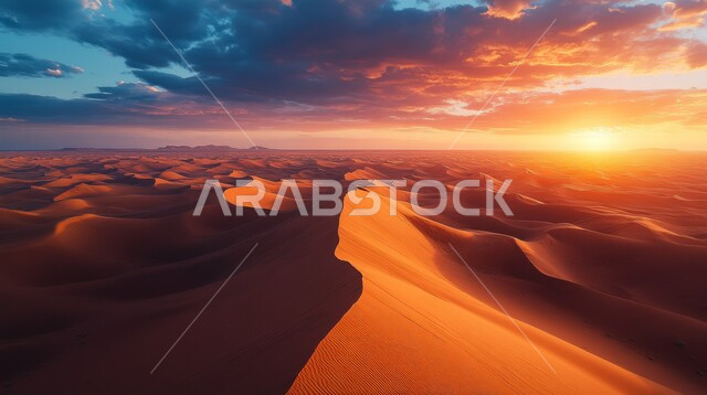 التضاريس والبيئة الجافة في الطبيعة الصحراوية، الكثبان والتلال الرملية الناعمة المتشكلة في الصحاري الخليجية, التكوينات والتشكيلات من الرمال الذهبية في الصحراء العربية، منظر غروب الشمس في السماء فوق حبات الرمل اللامعة