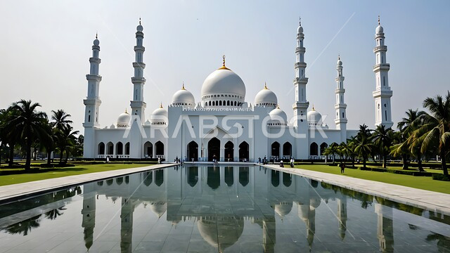 Worship, obedience and getting closer to God, the architectural art of building mosques in the Kingdom of Saudi Arabia, Islamic decorations and designs, minarets and domes built in the ancient style, the reflection of the mosque on the clear water, interest in planting plants and green palm trees