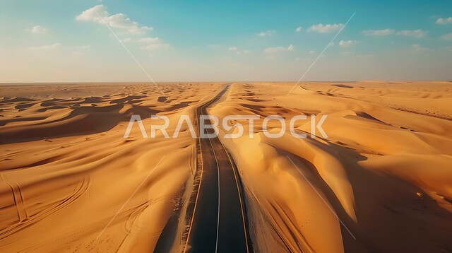 طريق اسفلتي ممتد على طول الصحراء, التلال والكثبان الرملية على أطراف الشارع في المناطق الصحراوية، تسهيل التنقلات بين المناطق البرية والمدن، التطور والنمو العمراني في صحاري المملكة العربية السعودية, شارع معبد لمرور السيارات وتسريع حركة المسافرين