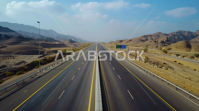 حركة مرور وسير السيارات على طريق اسفلتي بين التكوينات الصخرية والكثبان الرملية ،تهيئة طرقات السفر السريعة ،الطبيعة والبيئة الجبلية والمرتفعات في المملكة العربية السعودية، التلال والهضاب في المناطق الجبلية الصحراوية ،خط السير وسط الصحراء 