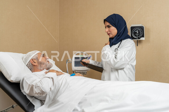 تقديم الخدمات والاستشارات الطبية للمراجعين، مفهوم الطب والرعاية الصحية، طبيبة عربية خليجية اماراتية ترتدي الحجاب والمعطف الابيض تقوم بتدوين معلومات مريض مسن عربي اماراتي مستلقي على السرير، مهن ووظائف نسائية، دراسة و مراجعة حالات المرضى