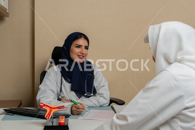 الاطلاع على نتائج التحاليل, تقديم الاستشارات في المراكز الطبيه في الامارات العربية المتحدة, متابعة السجل الطبي للمراجعين, العمل في القطاعات الصحية, طبيبة عربية خليجية اماراتية محجبة ترتدي المعطف الطبي تقوم بوصف الحالة المرضية للمريض، مهن ووظائف نسائية