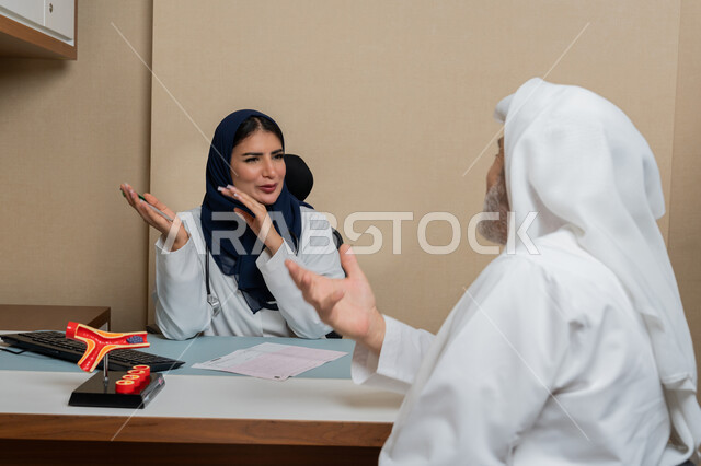 متابعة السجل الطبي للمراجعين, تقديم الاستشارات في المراكز الطبيه في الامارات العربية المتحدة، العمل في القطاعات الصحية, طبيبة عربية خليجية اماراتية محجبة ترتدي المعطف الطبي تقوم برفع يديها بايماءات الشرح والتوضيح للمريض، مهن ووظائف نسائية