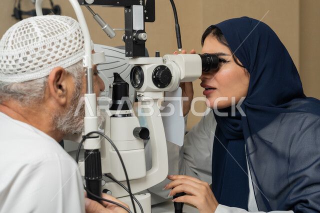 تشخيص وتحديد المشاكل البصرية، استخدام الأجهزة الحديثة المتطورة، صورة مقربة لطبيبة عربية خليجية اماراتية تقوم بفحص عيني رجل مسن اماراتي عربي خليجي بجهاز المنظار العيني، تقييم مدى الرؤية والكشف عن الامراض العينية، مفهوم الخدمات والرعاية الصحية في المشافي والمراكز الطبية