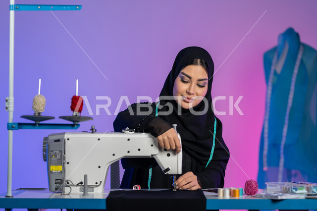 Art of sewing and fashion design, creating modern contemporary models, tailoring elegant women's clothing, close-up portrait of an Arab Gulf Emirati fashion designer wearing an abaya working on a machine, a Saudi woman sitting with gestures of confidence and integration, arts, crafts and professions, colorful background