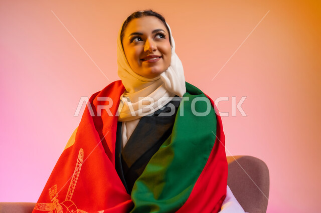 الاعتزاز بالانتماء للهوية، المشاركة بالاعياد والمناسبات الوطنية، الاحتفال بذكرى اليوم الوطني العماني، الفخر بالرموز والراية العمانية، بورتريه لشابه عربيه خليجيه عمانيه ترتدي العباءه والحجاب وتلف على جسدها العلم العماني ، مفهوم حب الوطن، خلفية ملونه