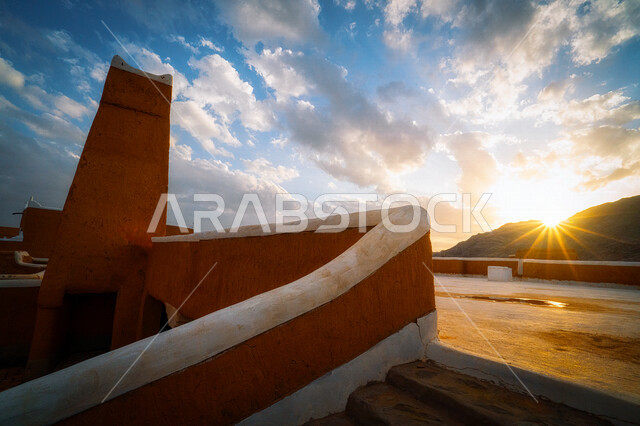 صورة لأشعة الشمس أمام الدرج الخارجي لمسجد قرية أشيقر التراثية الطينية القديمة في قرية أشيقر التراثية و تسمى بـالشقراء في الرياض في المملكة العربية السعودية ، أماكن سياحية تراثية ثقافية تاريخية في السعودية