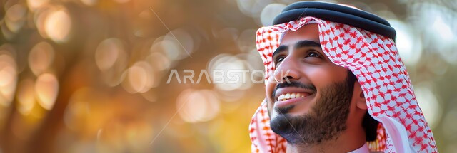 الرجولة والأناقة والاهتمام بالمظهر الخارجي، صورة مقربة لرجل سعودي عربي خليجي مبتسم يرتدي الثوب التقليدي والشماغ ينظر إلى الأعلى بتعابير البشاشة، التركيز على شيء  بايماءات السرور والسعادة، مفهوم التأمل والتخطيط للمستقبل