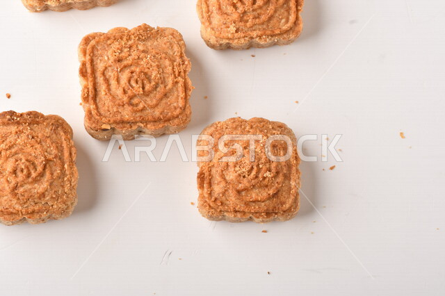 معمول محشو بالتمر ، مربع الشكل من الحلويات الشعبية الهشة اللذيذة على خلفية بيضاء ، صورة لكعك العيد الشهي محشو بالتمر ، حلويات شعبية طازجة