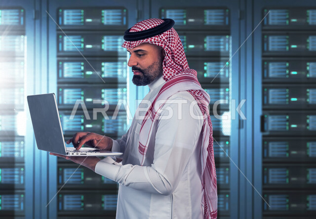 A Saudi Arabian Gulf employee working in the data center uses a technical device to manage servers, a group of Internet servers and servers, server shed, technology and technology