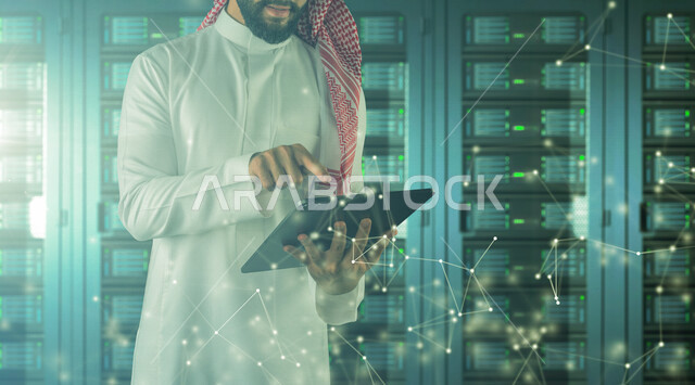 موظف عربي سعودي خليجي يعمل في مركز البيانات يقوم باستخدام جهاز تقني لادارة الخوادم, مجموعه من خوادم الانترنت والسيرفرات , حظيرة الخوادم, تقنيه وتكنولوجيا