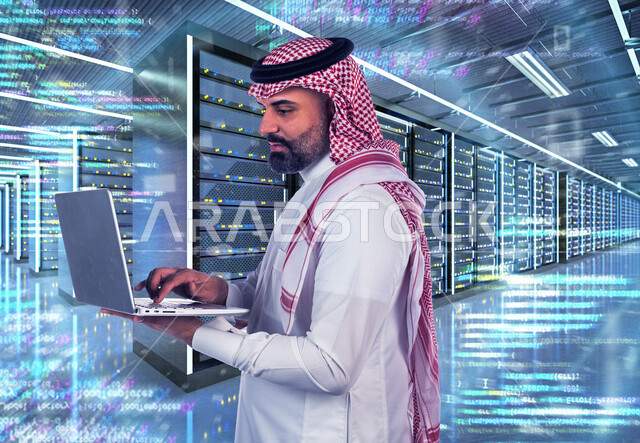 موظف عربي سعودي خليجي يعمل في مركز البيانات يقوم باستخدام جهاز تقني لادارة الخوادم, مجموعه من خوادم الانترنت والسيرفرات , حظيرة الخوادم, تقنيه وتكنولوجيا