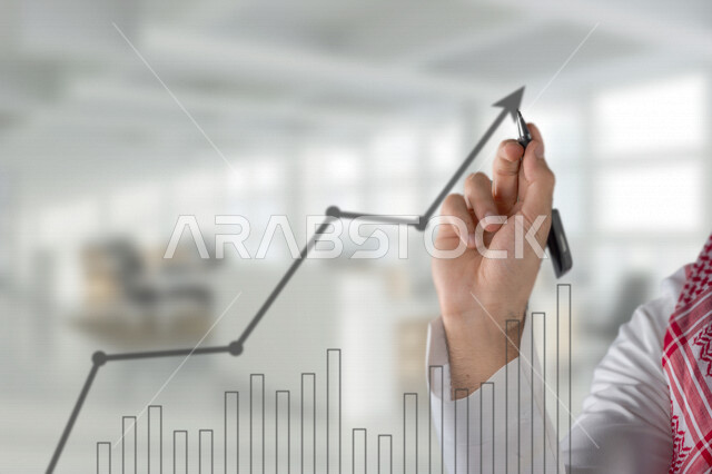 صورة مقربة ليد رجل عربي خليجي سعودي، دراسة السوق المالي والجدوة المالية، تحليل البيانات ورسمها بتقنية الهولوجرام، تخطيط وتحليل البيانات و المعلومات