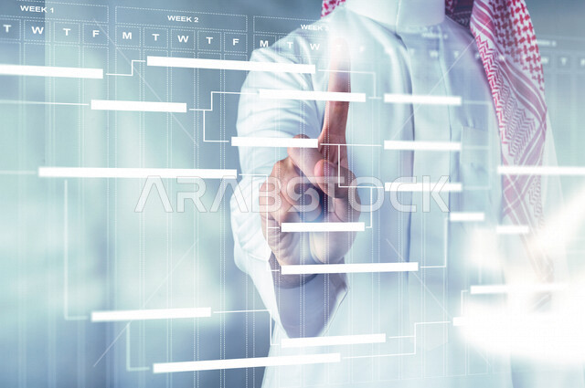 صورة مقربة ليد رجل عربي خليجي سعودي يضغط بأصبعه على رسومات بيانية، خطة شهرية، تحديد اليوم والاسبوع من خلال تقنية الهولوجرام ثلاثية الابعاد، تقنيات متطورة