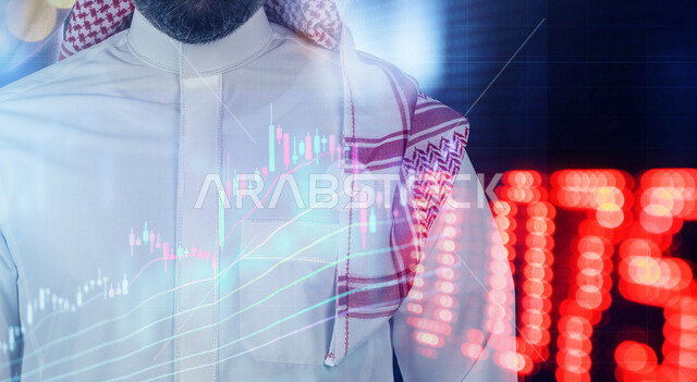 صورة مقربة لرجل عربي خليجي سعودي يقف وامامه شاشة رقمية اقتصادية، صعود ونزول البورصة المالية، الاستثمار المالي والاقتصادي، أعمال الكترونية تجارية، تقنيات متطورة