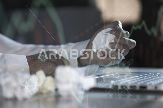 صورة مقربة ليد رجل خليجي سعودي، تقنية الهولوجرام ثلاثية الابعاد، استخدم الابتوب في متابعة أخبار وتطورات انتشار فايروس كورونا وعلاقتها بهبوط وصعود البورصة، الاسهم المالية والاقتصادية