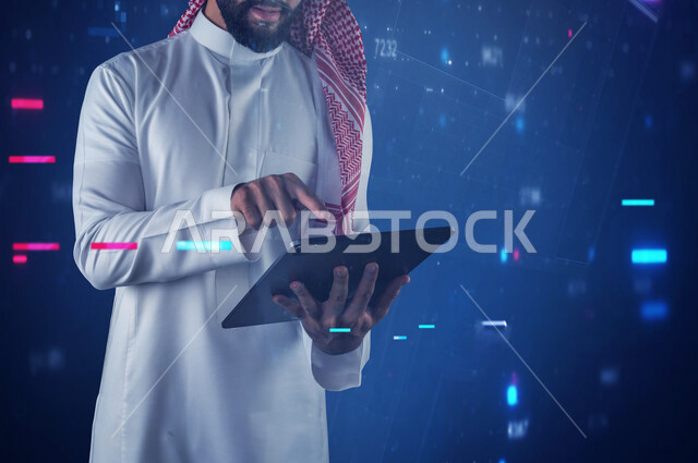 صورة مقربة لشاب سعودي خليجي يعمل من خلال جهاز التابليت المحمول، يضغط باصبعه على شاشة التابليت، استخدام تقنيات متطورة، تقنية وحاسب