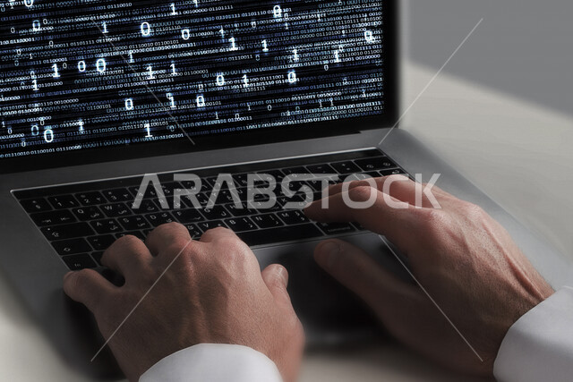 A young Saudi Gulf working as a web developer, using programming languages, developing and building websites and electronic applications, codes and algorithms, and computer technologies