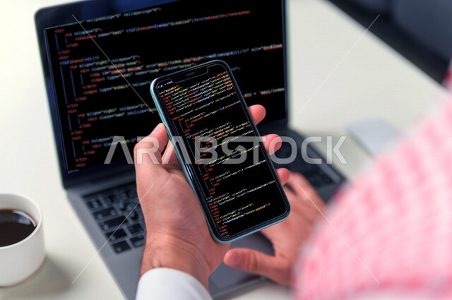 صورة يد شاب سعودي خليجي يعمل في وظيفة مطور ويب، استخدام لغات البرمجة، تطوير وبناء المواقع والتطبيقات الالكترونية، اكواد برمجية لبناء تطبيقات الهواتف الذكية