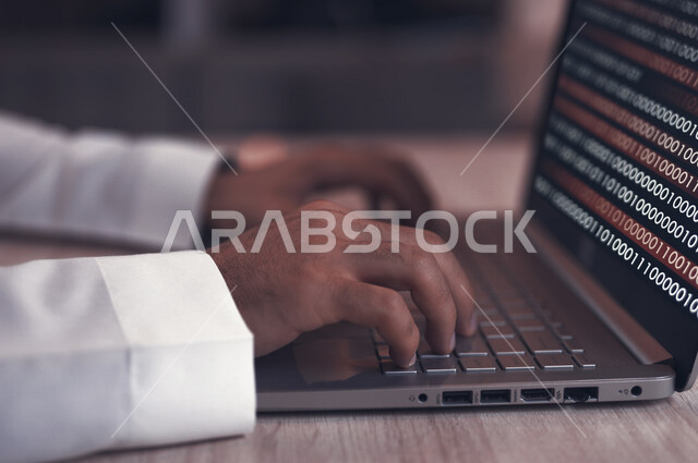 A young Saudi Gulf working as a web developer, using programming languages, developing and building websites and electronic applications, codes and algorithms, and computer technologies