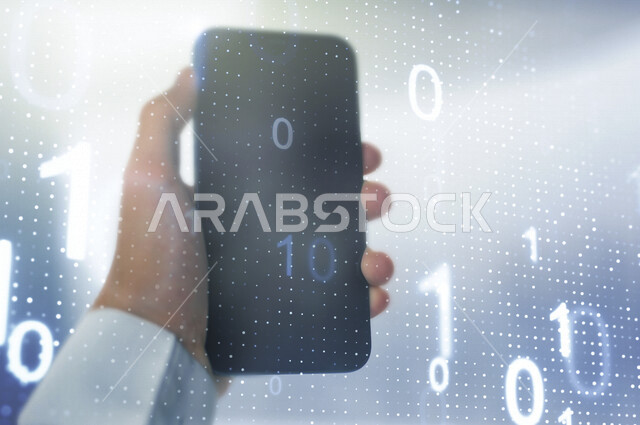 صورة مقربة ليد رجل عربي سعودي خليجي يحمل بيده هاتفه الذكي، جهاز تقني ذكي، اكواد وخوارزميات رقمية امام الهاتف المحمول