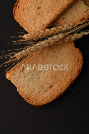 صورة لشرائح البقسماط المقرمشة على خلفية سوداء ، صورة مقربة لمخبوزات طازجة محمصة ، الشابورة