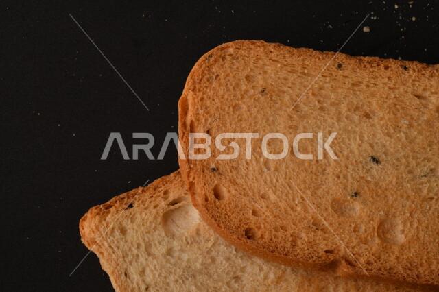 Image of crispy rusks on black background, close-up of freshly toasted baked goods, shaburah