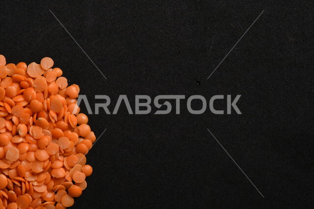 صورة مقربة لمجموعة من حبوب العدس الأحمر على خلفية سوداء ، بذور نباتي غذائي صحي ، حبوب العدس النباتي الجاف