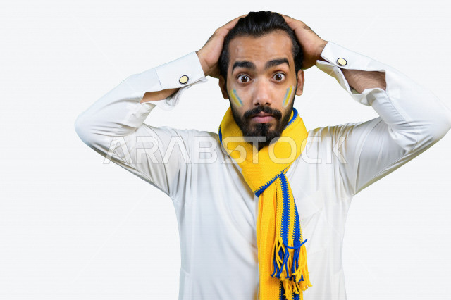 بورتريه لشاب عربي سعودي خليجي يضع وشاح نادي الفريق  ، مشجع لفريق النصر ، إيماءات وجه ويدين تدل على الصدمة و الذهول , أندية وتشجيع , خلفية بيضاء .