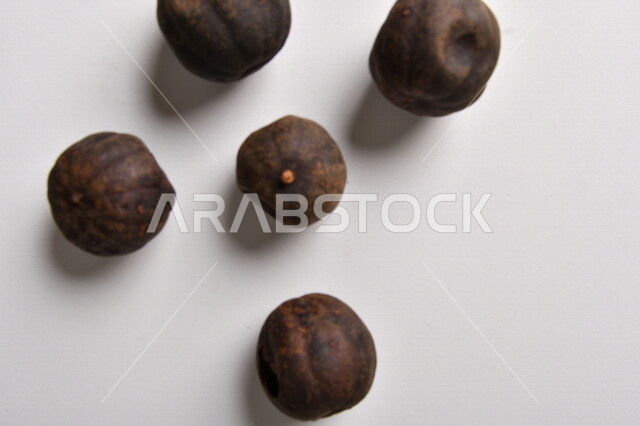 ثمار الجير الأسود المجفف على خلفية بيضاء ، الليمون العماني المجفف ، خلفية بيضاء لثمرة الليمون الحامض المجفف ، توابل وبهارات مجففة