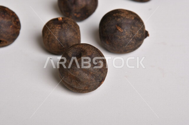 ثمار الجير الأسود المجفف على خلفية بيضاء ، الليمون العماني المجفف ، خلفية بيضاء لثمرة الليمون الحامض المجفف ، توابل وبهارات مجففة