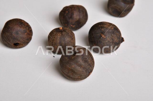 ثمار الجير الأسود المجفف على خلفية بيضاء ، الليمون العماني المجفف ، خلفية بيضاء لثمرة الليمون الحامض المجفف ، توابل وبهارات مجففة