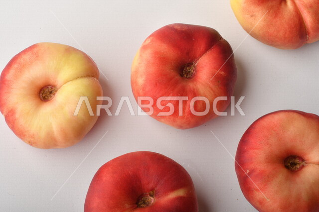 فاكهة الخوخ المسطح اللذيذ على خلفية بيضاء ، ثمرة الدّراق الصحية اللذيذة ، فاكهة الدُّراق المُبلَّط وتسمى كعب الغزال ، فاكهة صيفية