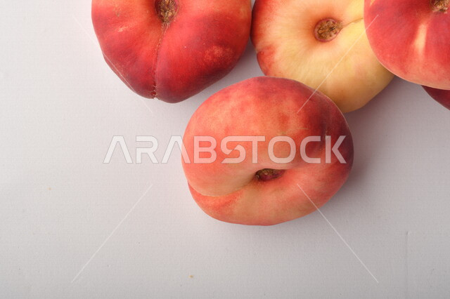 فاكهة الخوخ المسطح اللذيذ على خلفية بيضاء ، ثمرة الدّراق الصحية اللذيذة ، فاكهة الدُّراق المُبلَّط وتسمى كعب الغزال ، فاكهة صيفية