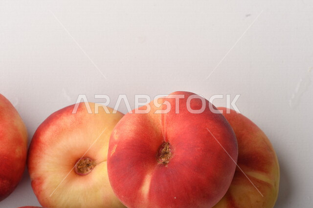 فاكهة الخوخ المسطح اللذيذ على خلفية بيضاء ، ثمرة الدّراق الصحية اللذيذة ، فاكهة الدُّراق المُبلَّط وتسمى كعب الغزال ، فاكهة صيفية