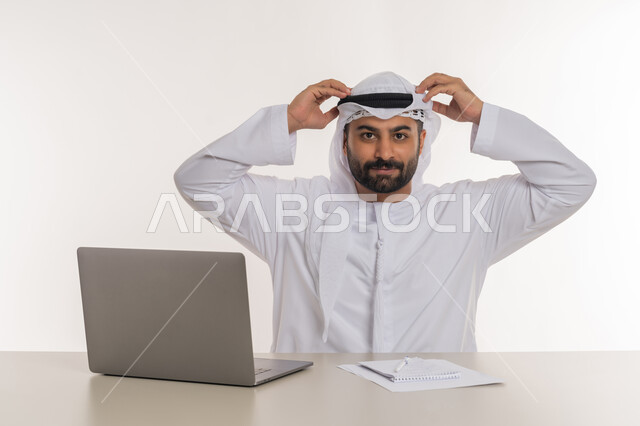 انجاز المهام وتحقيق الاهداف, مهن ووظائف مكتبية, بورتريه مقرب لرجل عربي خليجي اماراتي يرتدي الغترة والكندورة البيضاء ينظر الى الكاميرا يرفع يديه على رأسه بايماءات السرور والرضا, خلفية بيضاء