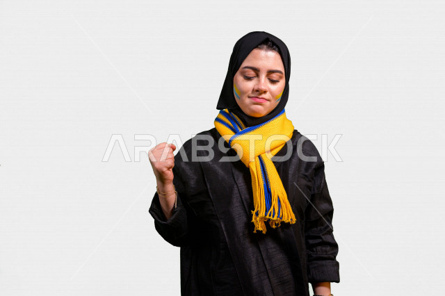 بورتريه لإمرأة عربية سعودية خليجية تضع وشاح نادي الفريق , مشجعة لفريق النصر , إيماءات وجه ويدين تدل على الشغف والحماس والفرحة بالفوز , أندية وتشجيع , خلفية بيضاء .