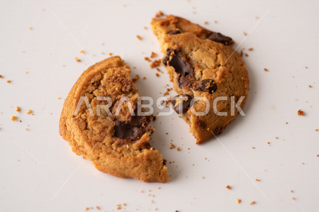 رقائق الشوكولاته الساخنه على خلفية بيضاء ، رقاقات البسكويت الهشة والخفيفة مع قطع الشوكولاته الداكنة اللذيذة ، كوكيز ، بسكويت برقائق الشوكولاتة ، حلويات مخبوزة طازجة