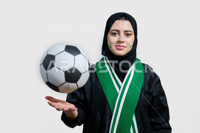 بورتريه لإمرأة عربية سعودية خليجية تضح وشاح نادي الفريق , مشجعة لفريق الأهلي وفريق السعودية , تمسك بيدها كرة القدم , إيماءات وجه ويدين تدل على الشغف والإنتماء للفريق , أندية وتشجيع , خلفية بيضاء .
