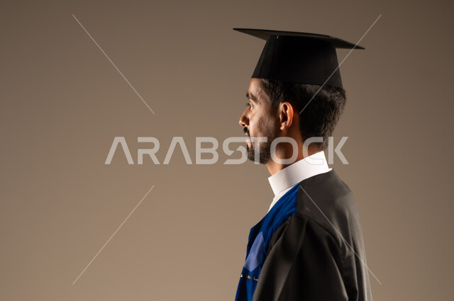  الشعور بالفرح والفخر والثقة بالنفس, مفهوم الاجتهاد والتفوق، الاحتفال بإنهاء الدراسة الجامعية، بورتريه مقرب من الجانب لطالب عربي سعودي خليجي يرتدي العباءه وقبعة التخرج, إيماءات الرضا والسرور, خلفية بنية 