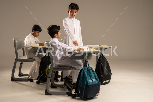 المشاركة والتعاون بين الزملاء، جودة أساليب التعلم الفعال، موسم العودة إلى المدارس، بورتريه لطلاب عربيين خليجيين سعوديين يرتدون الزي المدرسي يجلسون في مقاعدهم وأمامهم الكتب والمقررات المدرسية، أهداف التربية والتعليم في المملكة العربية السعودية، خلفية بيج