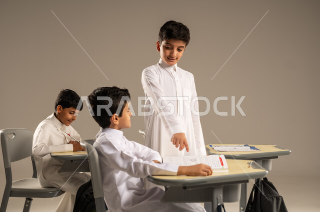 المشاركة والتعاون بين الزملاء، جودة أساليب التعلم الفعال، موسم العودة إلى المدارس، بورتريه لطلاب عربيين خليجيين سعوديين يرتدون الزي المدرسي يجلسون في مقاعدهم وأمامهم الكتب والمقررات المدرسية، أهداف التربية والتعليم في المملكة العربية السعودية، خلفية بيج