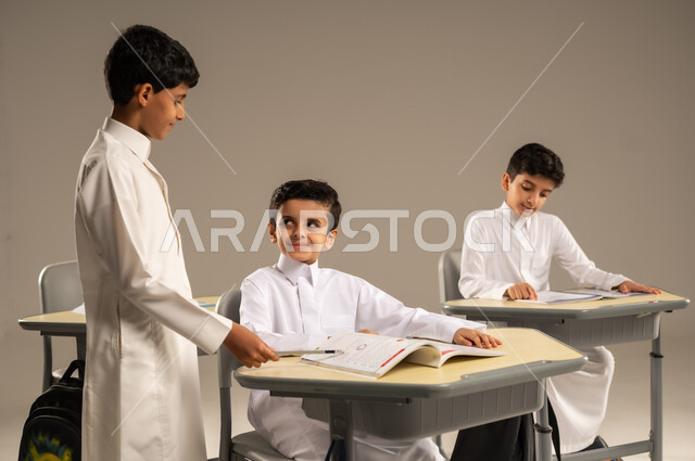 المشاركة والتعاون بين الزملاء، جودة أساليب التعلم الفعال، موسم العودة إلى المدارس، بورتريه لطلاب عربيين خليجيين سعوديين يرتدون الزي المدرسي يجلسون في مقاعدهم وأمامهم الكتب والمقررات المدرسية، أهداف التربية والتعليم في المملكة العربية السعودية، خلفية بيج