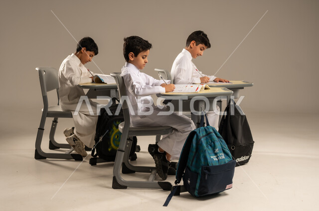 المشاركة والتعاون بين الزملاء، جودة أساليب التعلم الفعال، موسم العودة إلى المدارس، بورتريه لطلاب عربيين خليجيين سعوديين يرتدون الزي المدرسي يجلسون في مقاعدهم وأمامهم الكتب والمقررات المدرسية، أهداف التربية والتعليم في المملكة العربية السعودية، خلفية بيج