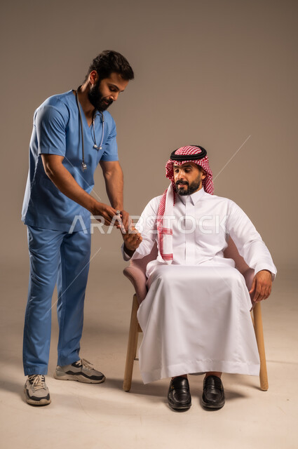 جهاز قياس سكر الدم لمرضى السكري، العمل في القطاع الصحي في السعودية، بورتريه لممرض يرتدي اليونيفورم يقوم بفحص نسبة السكر في الدم لرجل مريض عربي خليجي سعودي يرتدي الثوب التقليدي والشماغ يجلس على الكرسي، تقديم الفحص الطبي والعناية الصحية المنزلية، خلفية بيج