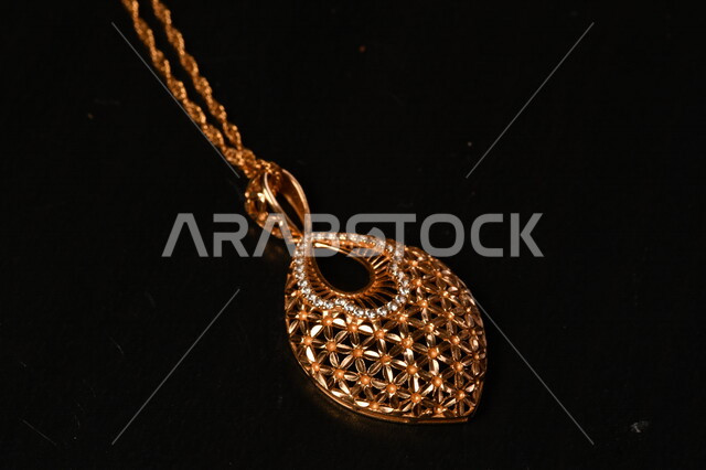 صورة لقلادة ذهبية على خلفية سوداء ، سلسلة ذهبية توضع حول العنق , محل مجوهرات , ذهب ثمين أصفر , مجوهرات ثمينة ,سلسة ذهبية مزخرفة لامعة